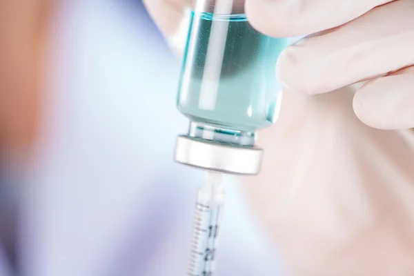 Closed up hand of Nurse fills syringe from injection vial on whi — Stock Photo, Image