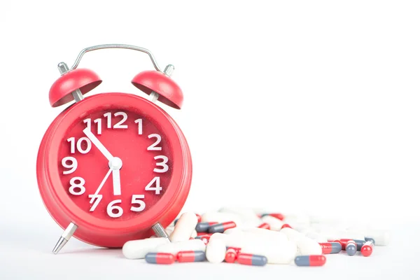 Red clock and capsule show healthcare and medicine time concept — Stock Photo, Image