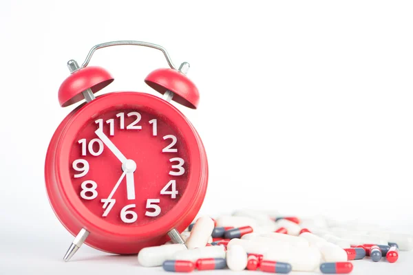 Horloge rouge et capsule montrent les soins de santé et la médecine concept de temps — Photo