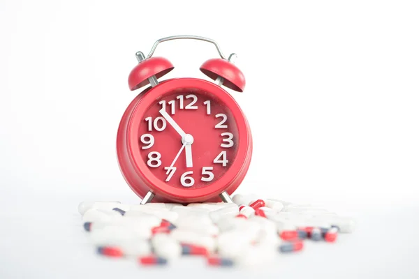 Red clock and capsule show healthcare and medicine time concept — Stock Photo, Image