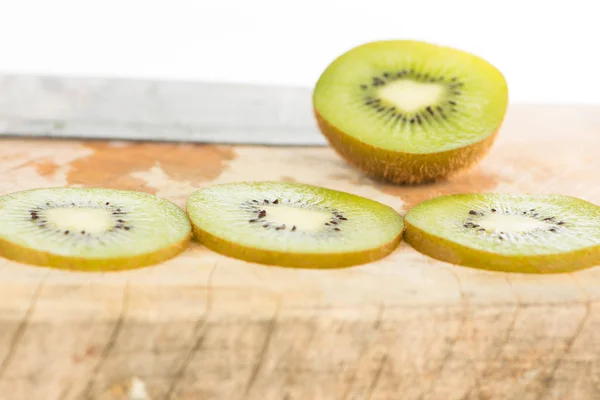 Sliced kiwi fruit on wood floor — Stock Photo, Image