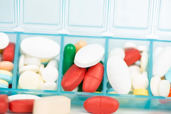 Лекарственные таблетки и капсулы в еженедельной таблеточном ящике — стоковое фото