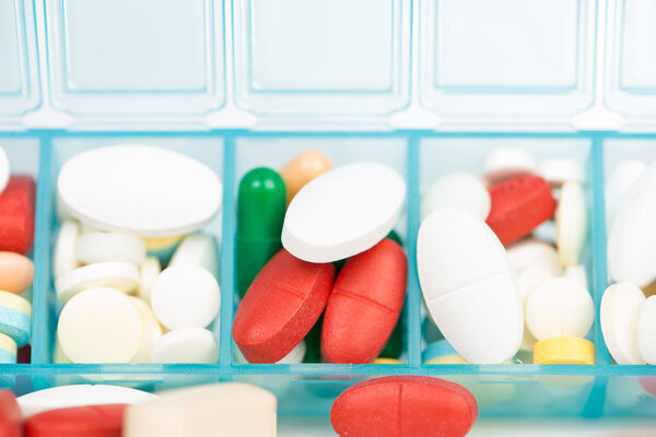 Лекарственные таблетки и капсулы в еженедельной таблеточном ящике
