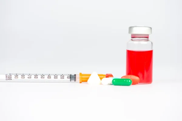 Red liquid in injection vial and medicine tablet — Stock Photo, Image