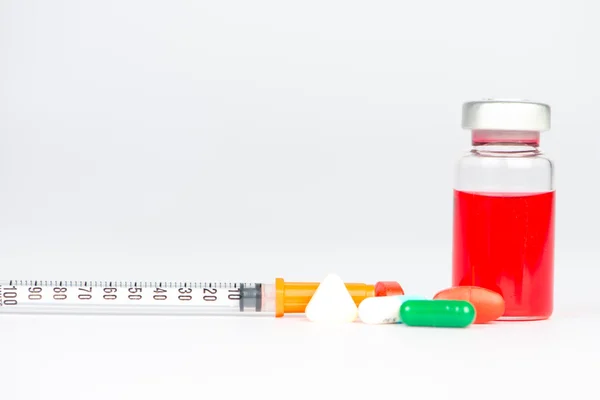 Red liquid in injection vial and medicine tablet — Stock Photo, Image