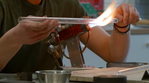 Homme soufflant un tube de verre avec torche — Video