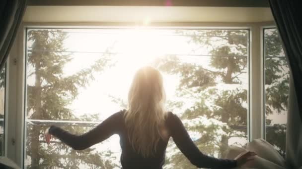 Frau öffnet Vorhänge mit hellem Sonnenlicht dahinter — Stockvideo
