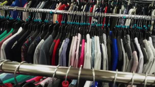 Moción lenta a través de bastidores de ropa diferente — Vídeo de stock