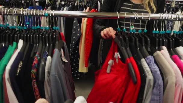 Moción lenta a través de bastidores de ropa diferente — Vídeo de stock