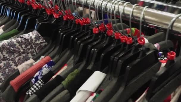 Moción lenta a través de bastidores de ropa diferente — Vídeo de stock