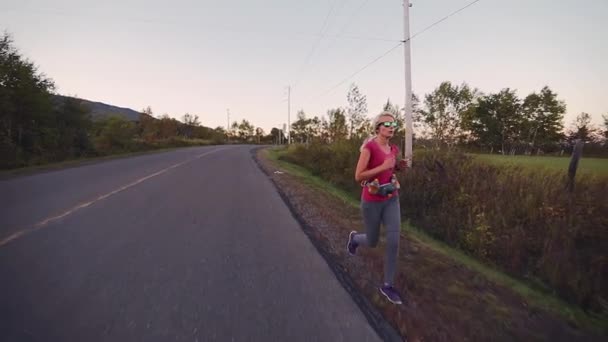 砂利の上で一人で長距離を走る女のスローモーション — ストック動画