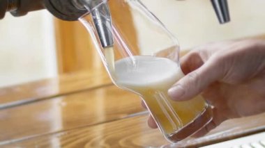 Musluğun üzerine puslu bir IPA dökülüyor.