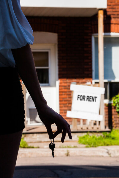 Молодая женщина стоит перед своей новой квартирой
