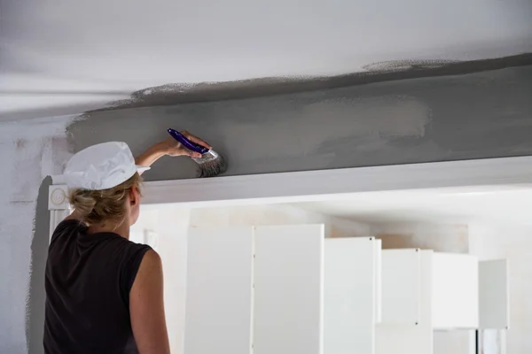 Mulher pintando as bordas do teto — Fotografia de Stock