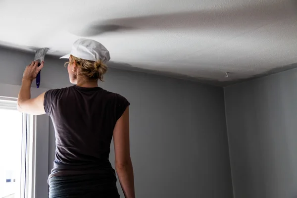 Mulher pintando as bordas do teto — Fotografia de Stock