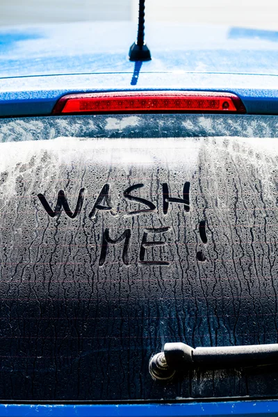 Lave-me palavras em uma janela de carro sujo — Fotografia de Stock