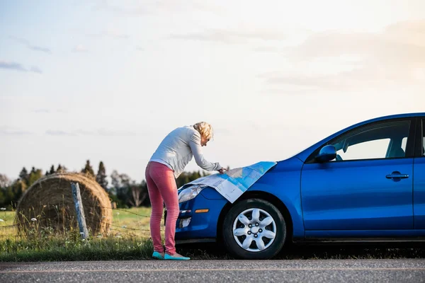 Nachdenkliche Frau auf dem Land beim Blick auf eine Landkarte — Stockfoto