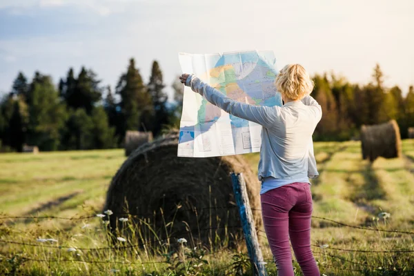 Mujer perdida en una escena rural mirando un mapa — Foto de Stock