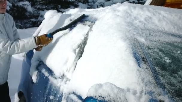 Nő eltávolítja a havat az autóból — Stock videók