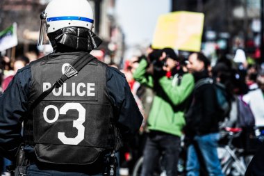  Ayrıntılı bir polis karşı karşıya protestocular arkasında.