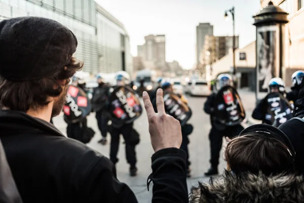 Homem fazendo um sinal de paz na frente de policiais — Fotografia de Stock