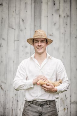 Farmer Holding a Beige Chicken clipart