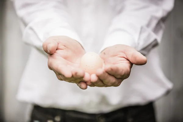 Farmář, ukazující vajíčko — Stock fotografie