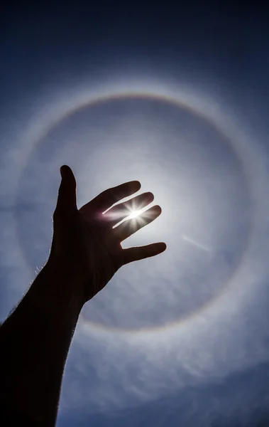 Silhouette main avec halo solaire circulaire — Photo