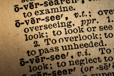 Close-up of the word OVERSEE and its definition