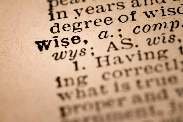 Крупный план открытого словаря, показывающего слово WISE — стоковое фото