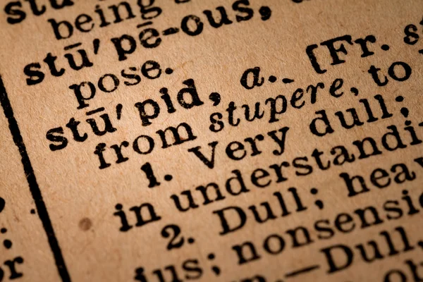 Κοντινό πλάνο ενός άνοιξε το λεξικό δείχνει την ηλίθια λέξη — Φωτογραφία Αρχείου