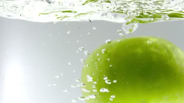 180fps Super Zeitlupe grüner Apfel fällt in klares Wasser — Stockvideo