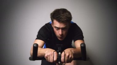 Sprint ve sabit bir bisiklet üzerinde terleme motive genç adam