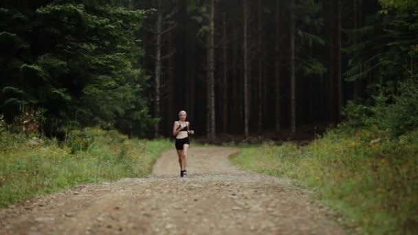 Mujer corriendo sola en un camino de grava — Vídeos de Stock