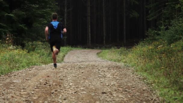 Homem correndo sozinho em uma estrada de cascalho — Vídeo de Stock