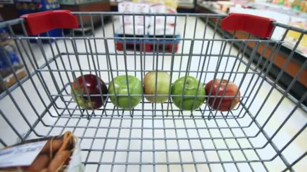 Détail de l'épicerie avec peu de pommes dans le chariot — Video