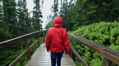 Young Woman Walking on a Boardwalk during a rainy day of Summer