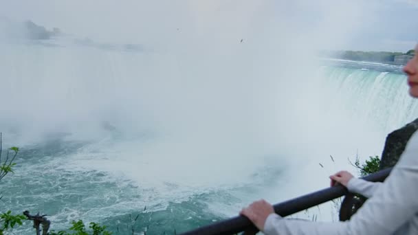 Молода білявка дивлячись на Ніагарський водоспад — стокове відео