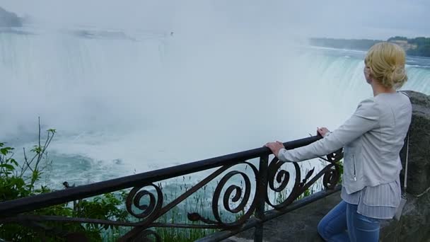Jonge Blonde vrouw kijken naar de Niagara Falls — Stockvideo