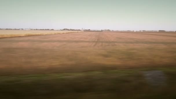 Campos borrosos Vista desde una ventana de tren rápida — Vídeos de Stock