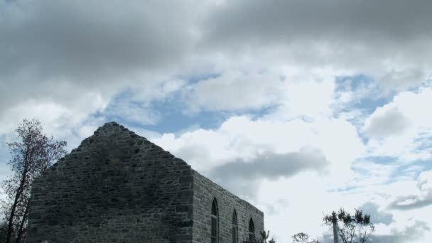 Video inclinado desde el cielo de una iglesia abandonada y un cementerio — Vídeos de Stock