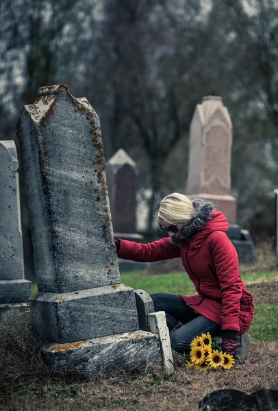 Donna con girasoli in un cimitero — Foto Stock