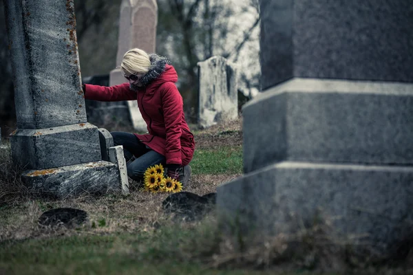 Femme avec tournesols dans un cimetière — Photo