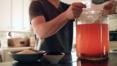 Adam tülbent Kombucha üstüne koyarak