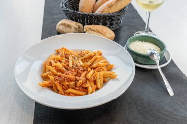 Beyaz tabakta servis edilen bolonez makarnası.