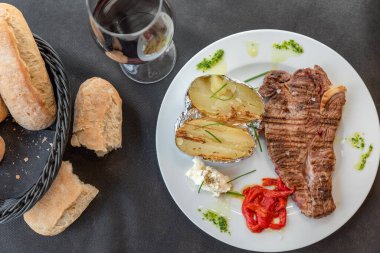 Ekmek ve şarapla servis edilen kızarmış patatesli fileto.