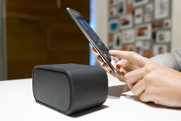 Woman connecting smartphone to speakers — Stock Photo, Image