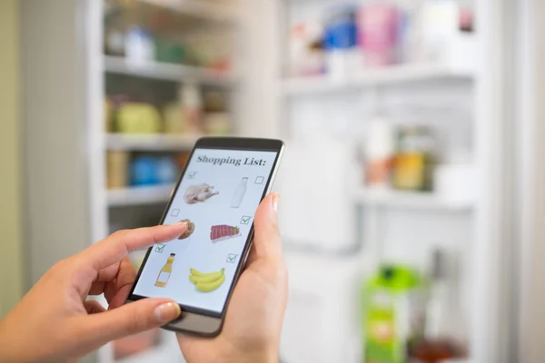 Woman makes shopping list on phone — Stock Photo, Image