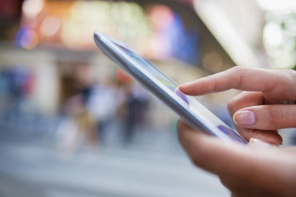 Mujer sosteniendo el teléfono móvil en las manos — Foto de Stock