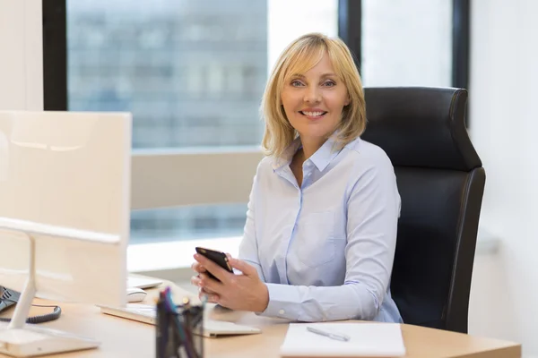 Affärskvinna som använder smartphone på kontoret — Stockfoto
